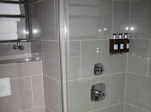 Refillable shampoo, soap and lotion containers in a hotel bathroom