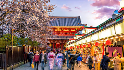 Tourists at the shopping street in Asakusa with Sensoji Temple in the background