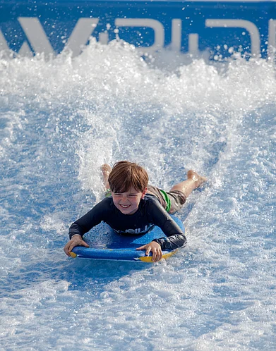 Shutterstock : Kid enjoying flowboarding at Wave House Sentosa