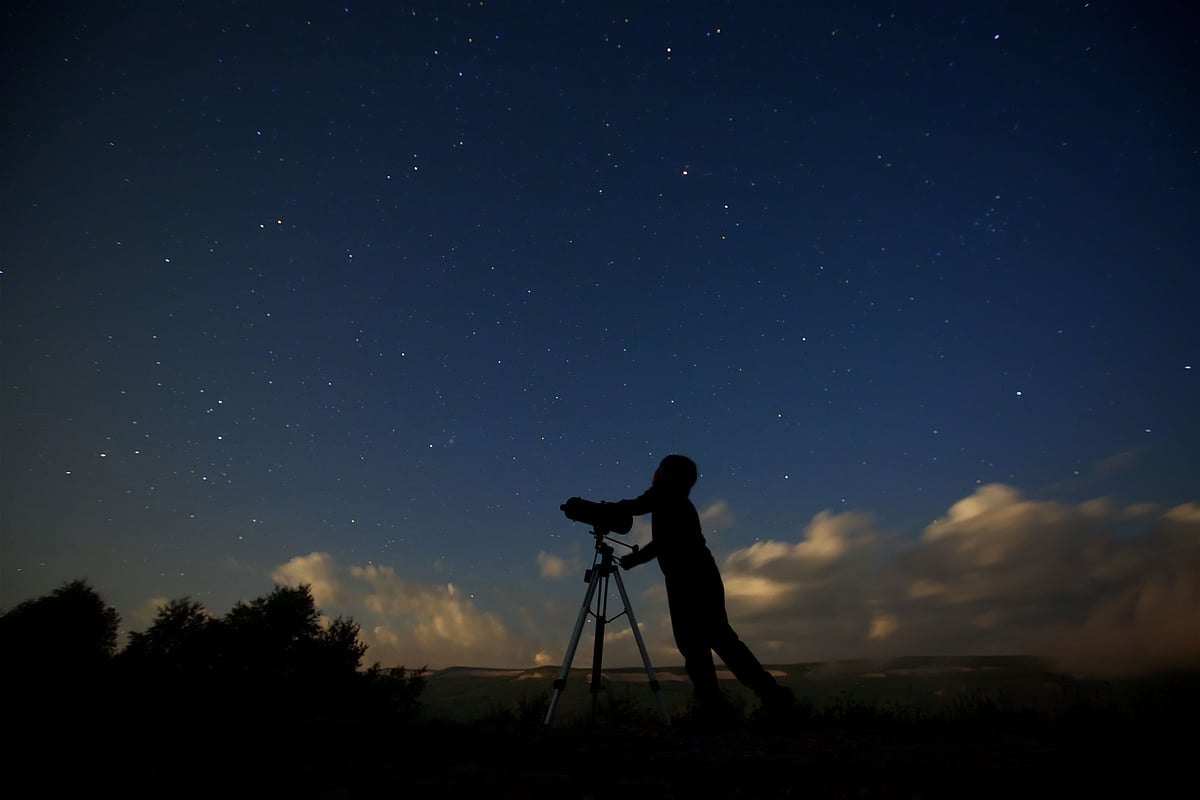 Shutterstock : A child with a telescope studying the starry sky and galaxies