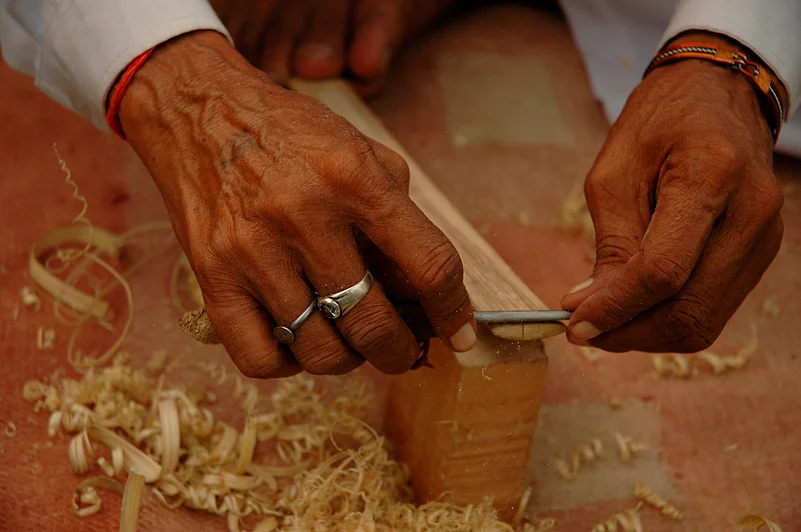 An artisan using wood to make handicrafts