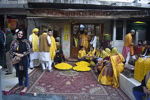 People wait for the Basant Panchami events to begin at the Nizamuddin Dargah