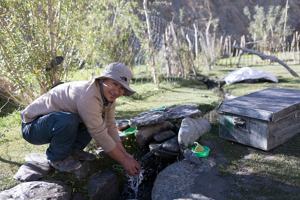 Cleaning dishes with the campsites water pipe in Ladakh