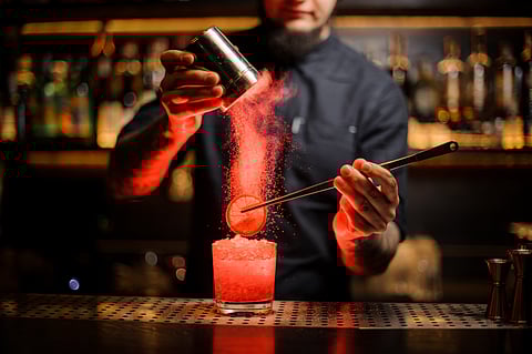 A bartender plays around with a Scotch drink