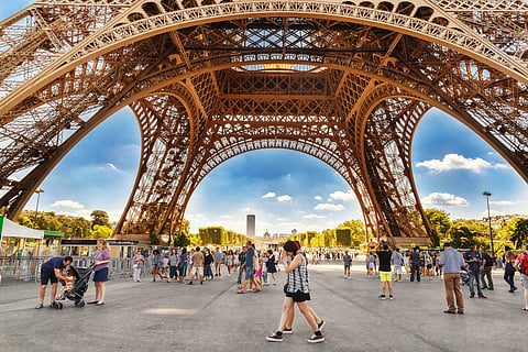 Tourists walking under the Eiffel Tower 