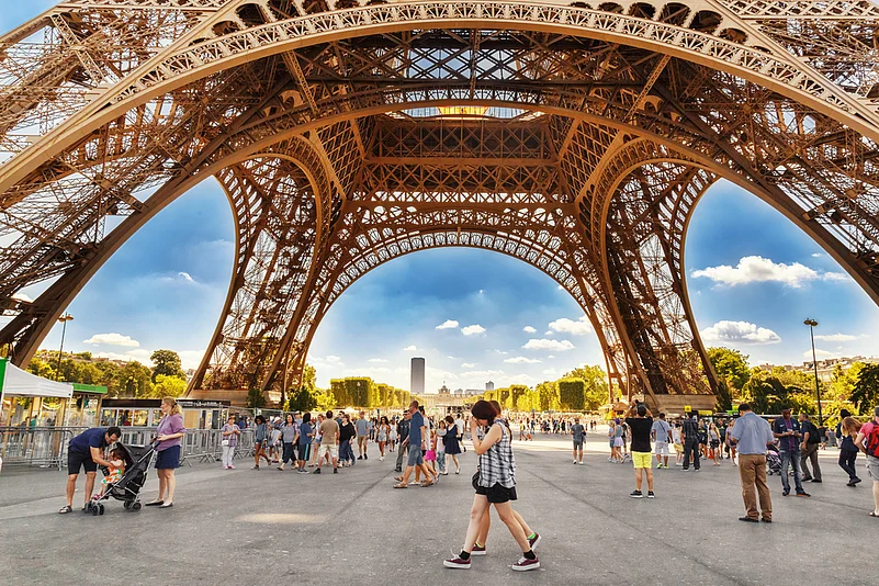 Tourists walking under the Eiffel Tower
