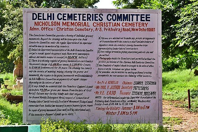 A board about the cemetery and timings