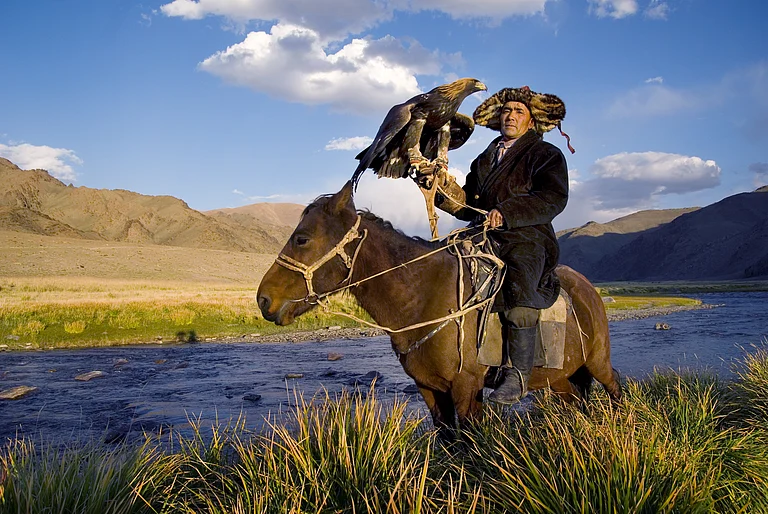 Kazakh man with a trained golden eagle - Shutterstock