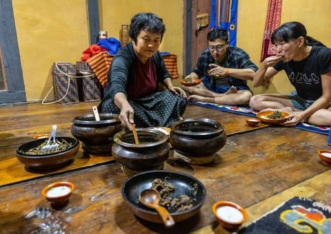 Guests sharing food with a homestay host