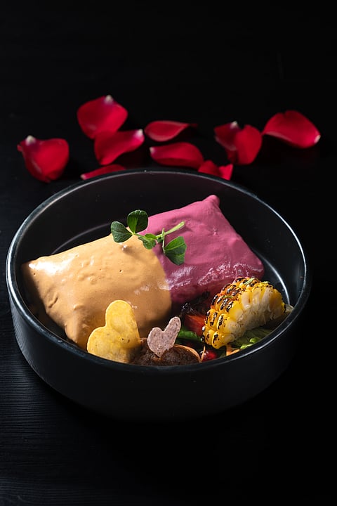 A luxurious crown of pink mole and queso sauce adds a touch of Valentine's whimsy to the dish