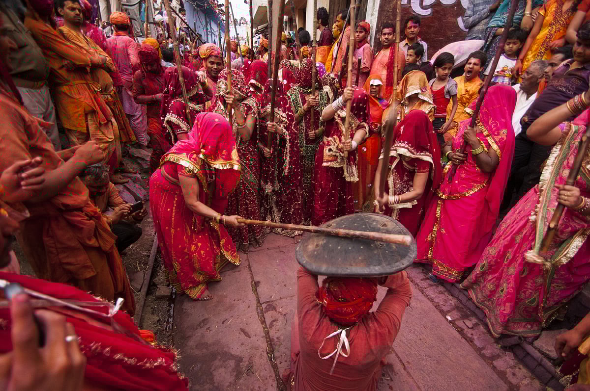 Women beat up men with long sticks as a ritual in the Lathmar Holi celebrations