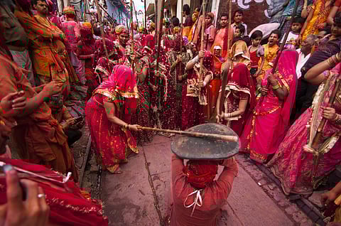 Women beat up men with long sticks as a ritual in the Lathmar Holi celebration