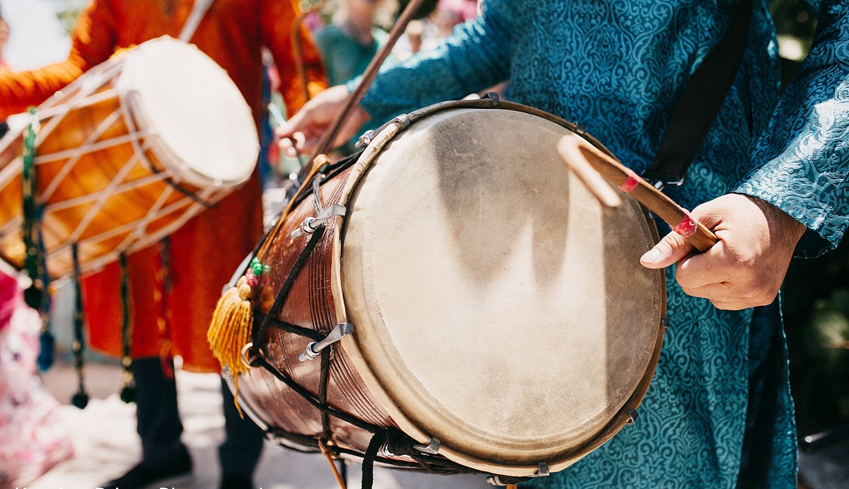 A man beats the dhol at a traditional Punjabi performance
