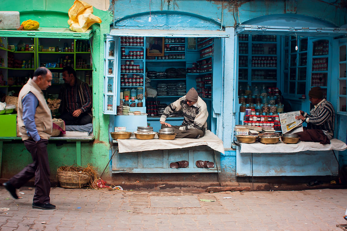 Traditional street life with a sellers of small spices shops & passers-by in Varanasi