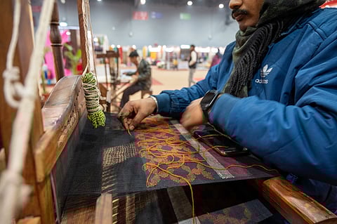 An artisan from Nadia, West Bengal, crafts patterns and designs while creating  a Jamdani sari on a traditional wooden handloom