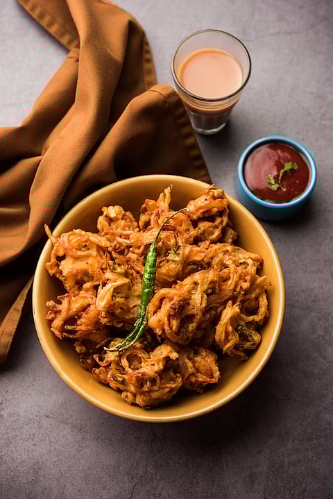 A bowl of pakoras garnished with green chilli