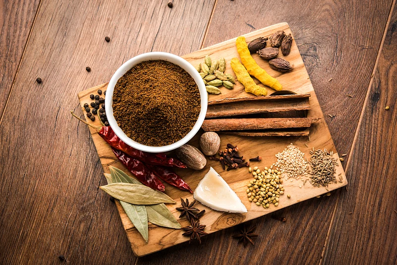 Indian Garam masala powder in bowl and its ingredients colourful spices