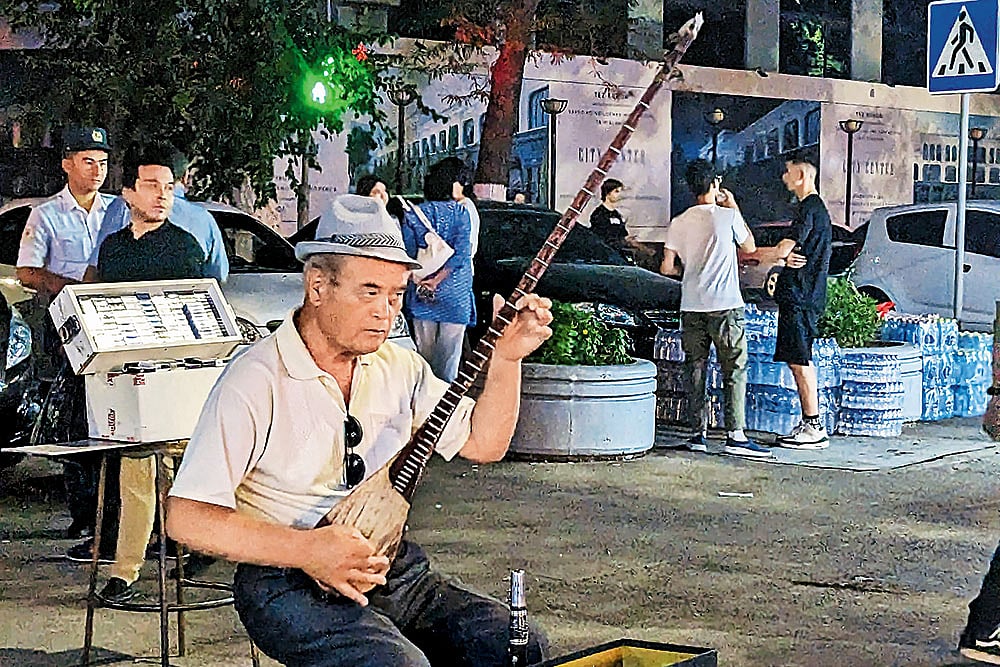 An Uzbeki man plays the dutar at the Sayilgoh Street