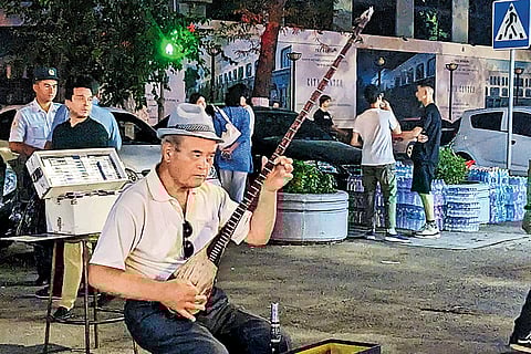 An Uzbeki man plays the dutar at the Sayilgoh Street