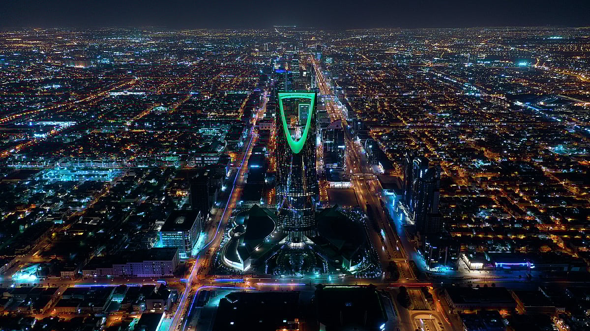 Aerial view of Riyadh at night, with the illuminated Kingdom Tower in the center