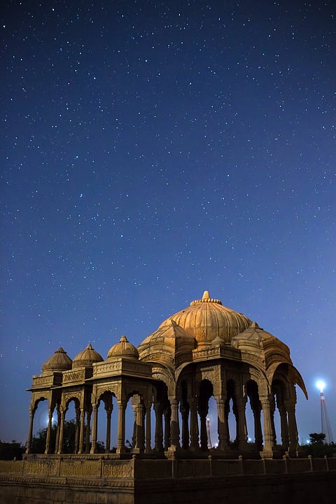 The royal cenotaphs of historic rulers, also known as Jaisalmer Chhatris, seen in the night sky full of stars