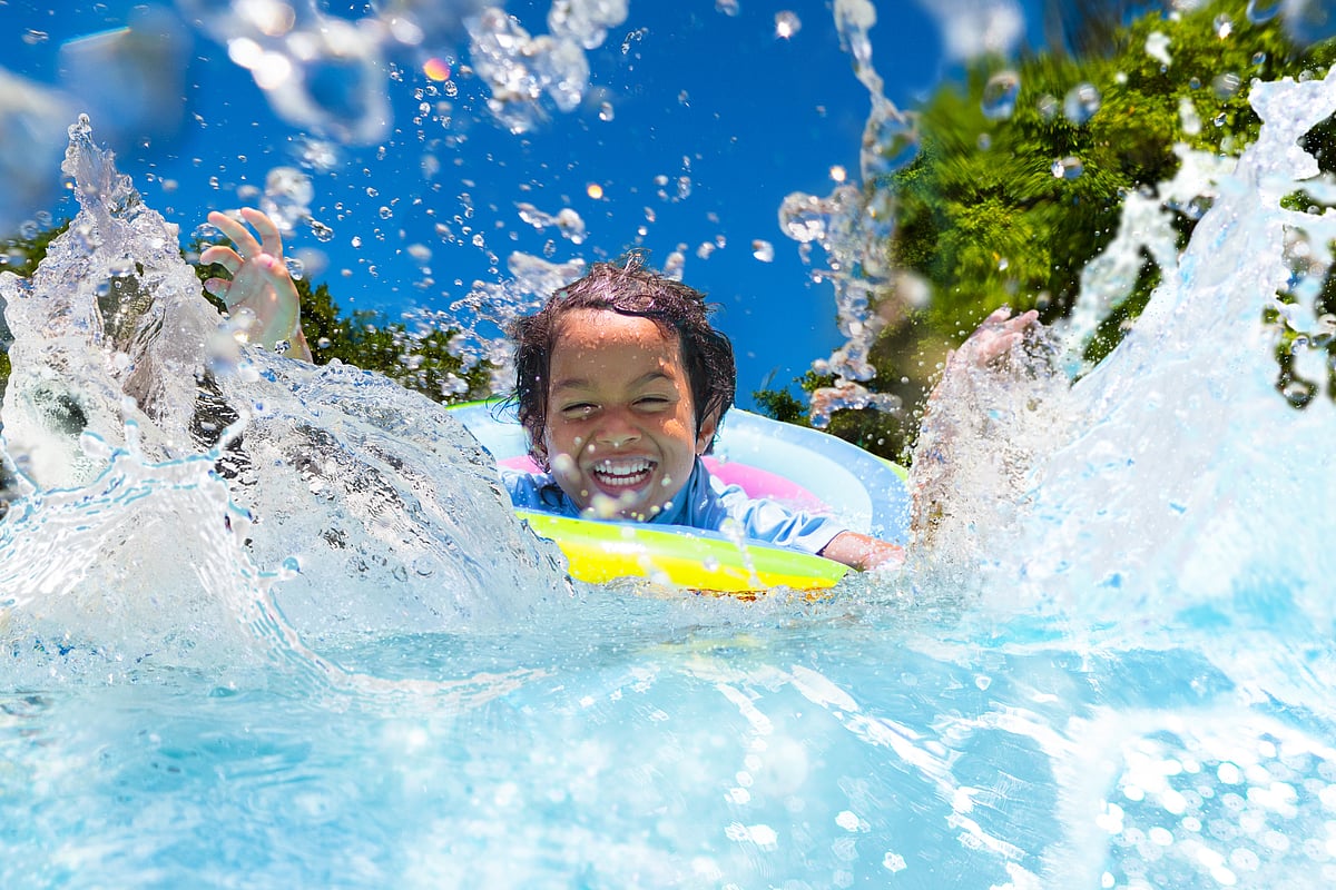 A child swims in a pool in summer