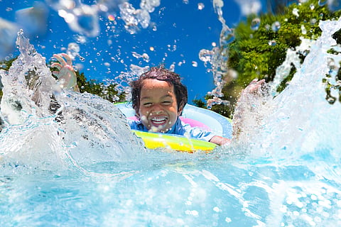 A child swims in a pool in summer