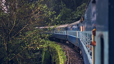 Shutterstock : An Indian train running through the green forest over a bridge in Konkan route
