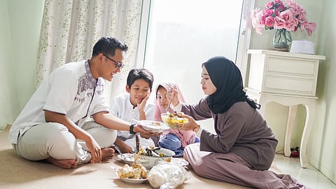 A family sits to enjoy a feast on Eid