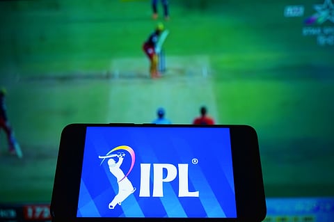 A cricket match happening in a stadium with the logo of the game on front