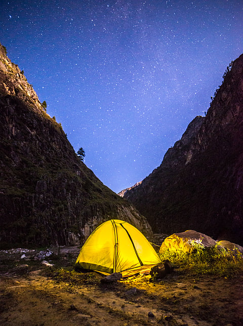 Campers under the brightly-lit starry sky in Chopta