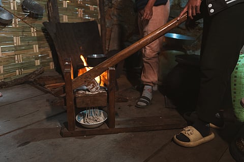 Puttang (buckwheat noodles) being squeezed out of a takto shing, a traditional contraption used for making noodles 