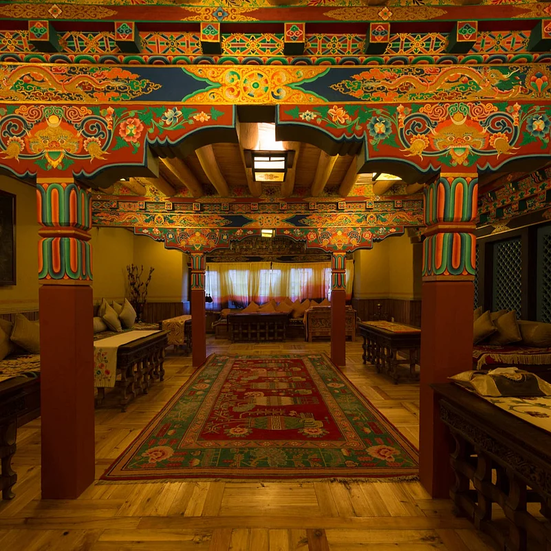 The dining room adorned with rich murals and intricately designed pillars.