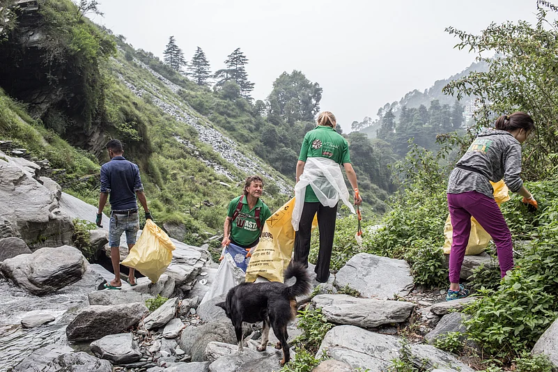 Volunteers from the NGO Waste Warriors clean the area near the Bhagsu Waterfall in McLeodGanj