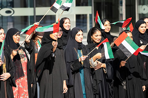 Women and girls wave UAE flags during National Day celebrations