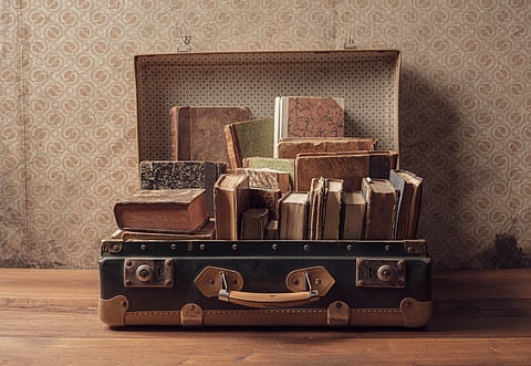 Heavy items like books and shoes should be placed near the wheels of the suitcase for stability