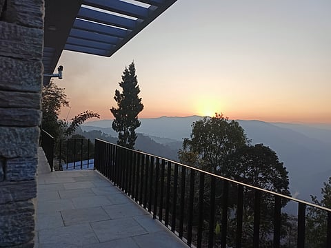 Catch a glimpse of the setting sun in the lap of Mount Kanchendzonga from the homestay's balcony