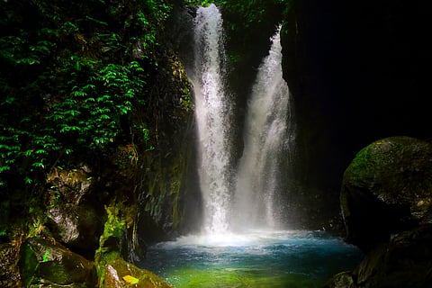The Gitgit Twin Waterfall divides off into two tiers to crash down on the rocks below