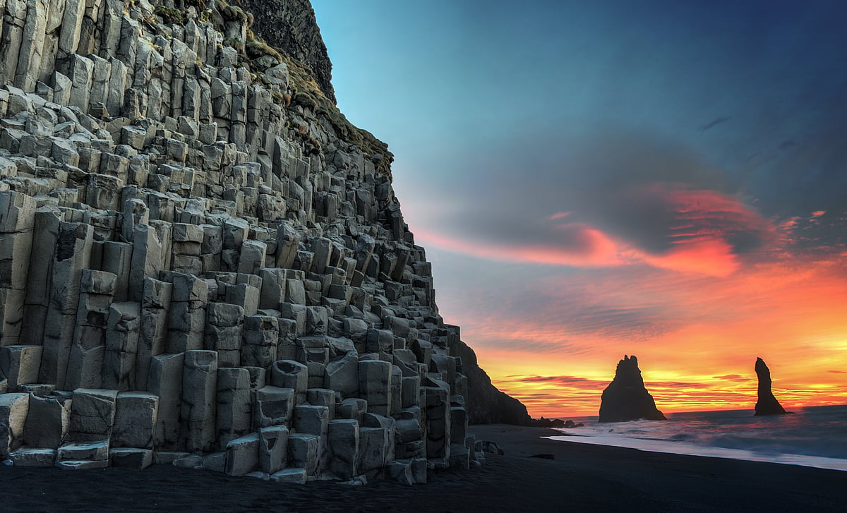 Wide view of Reynisdrangar rock formations on Reynisfjara Beach at sunrise, Halsanefhellir, Iceland