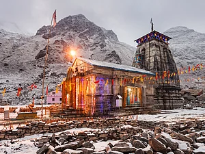 saiko3p/Shutterstock : The Kedarnath temple lights at night with mountains in the background in Uttarakhand