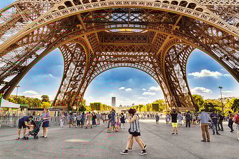 Tourists walking under Eiffel Tower 