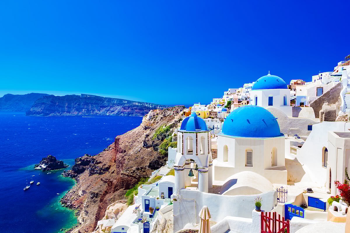 Traditional houses and churches with blue domes over the Caldera, Aegean Sea in Greece