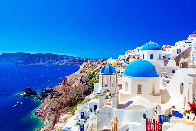 Traditional houses and churches with blue domes over the Caldera, Aegean Sea in Greece
