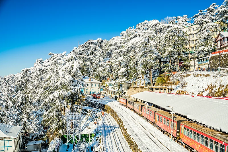 The toy train passing through a snow-clad Shimla station