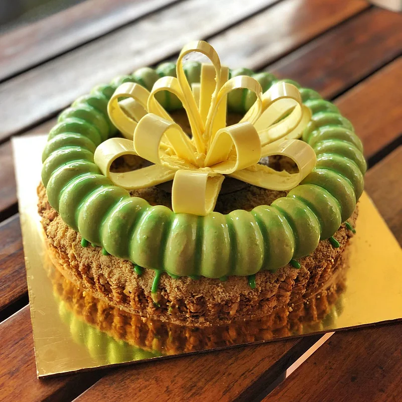 A cake made of granola, gin and tonic ganache, yuzu curd, pistachio crumble, matcha mousse and white chocolate at Le Flamington