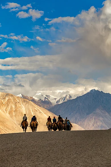 Shutterstock : A group of people trudge on horses in Ladakh