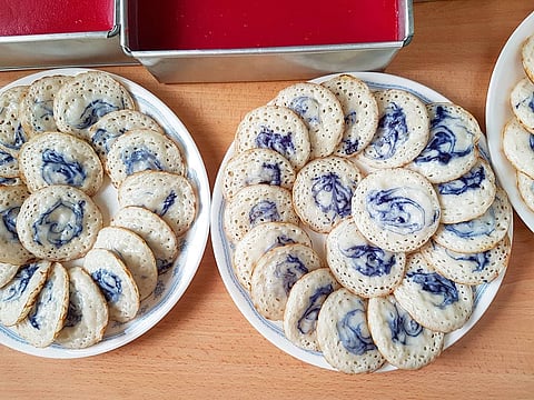 Apom Berkuah with its distinctive blue swirl is a pancake crafted from fermented rice flour and coconut milk