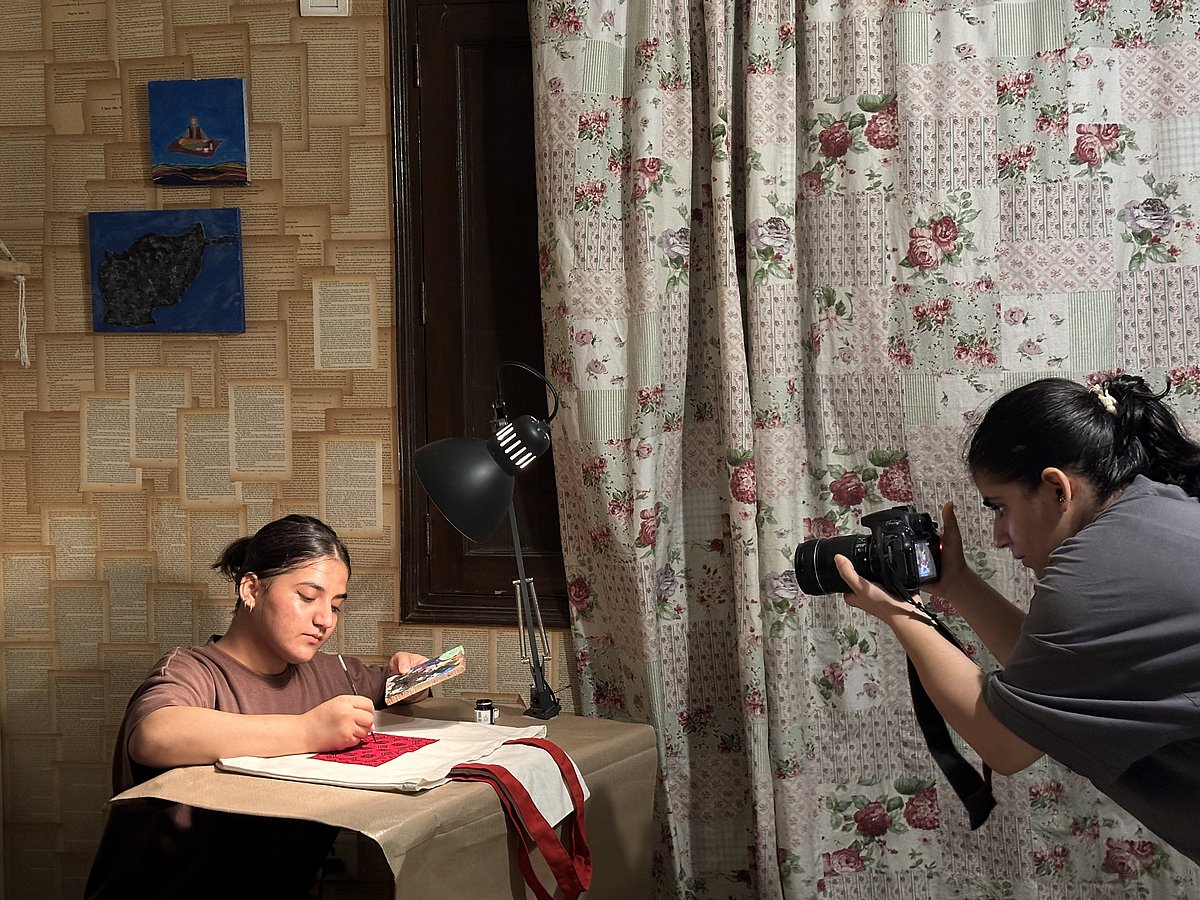 Hawa Kakar (left) photographing Heela as she creates her miniature art