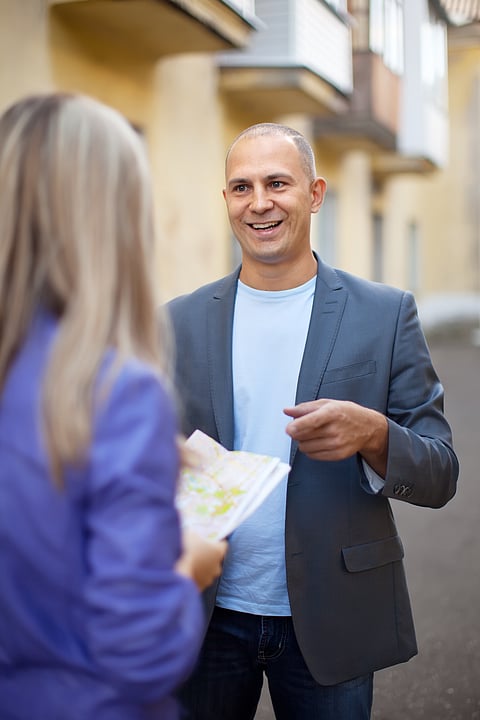 A man asks a woman for the direction for a place