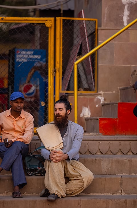 A tourist communicates with a man in Varanasi